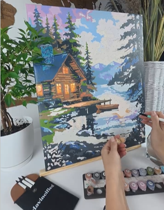 Peaceful evening paint by numbers setup on desk with warm lighting and tea, showing a screen-free relaxation space