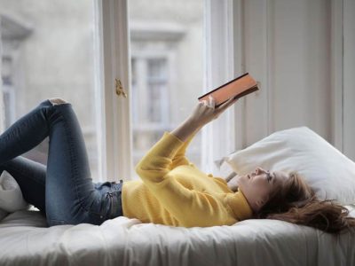 student on bed reading book